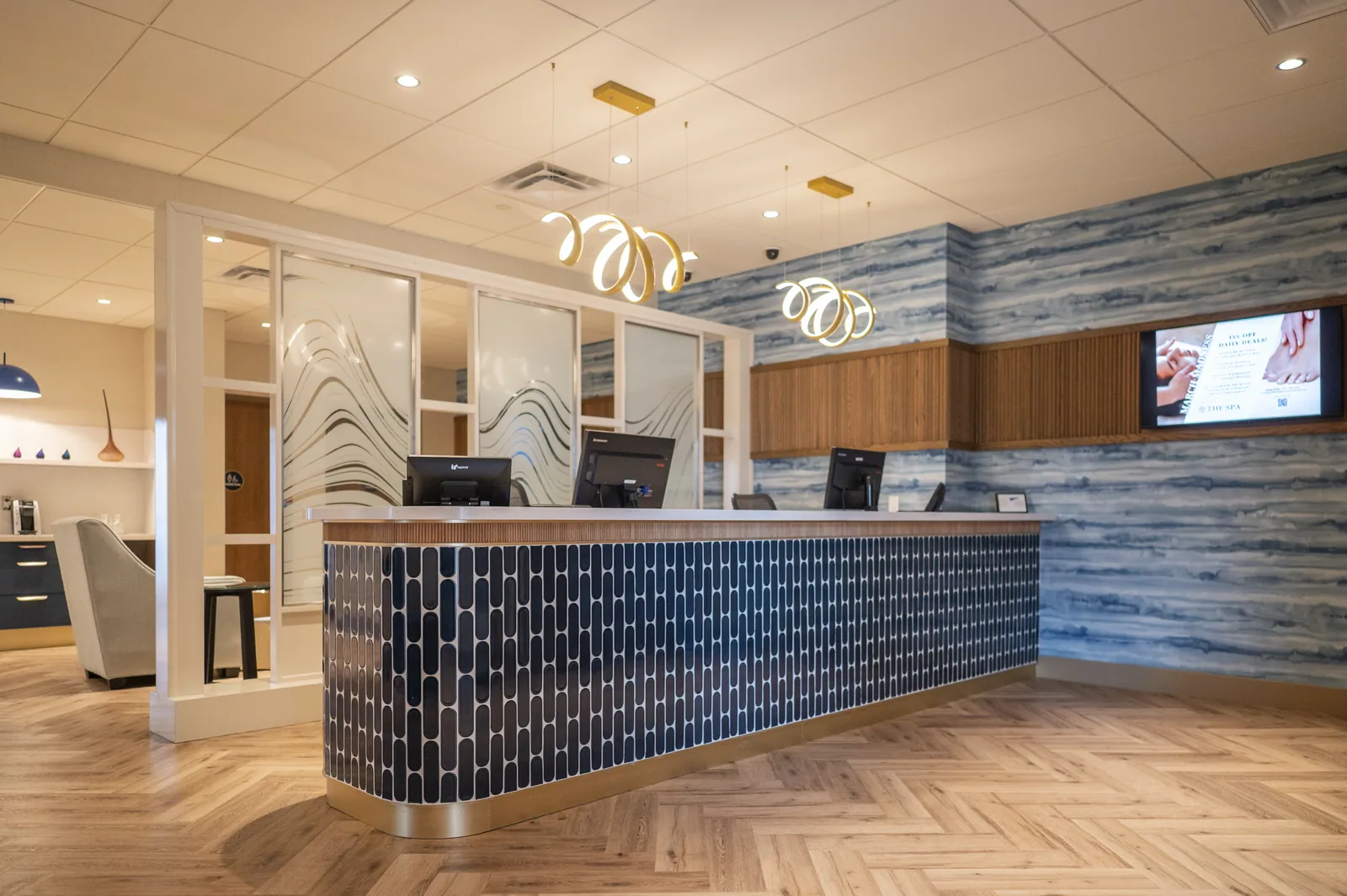 Reception desk of the hotel with screens, blue, brown, and gold accents