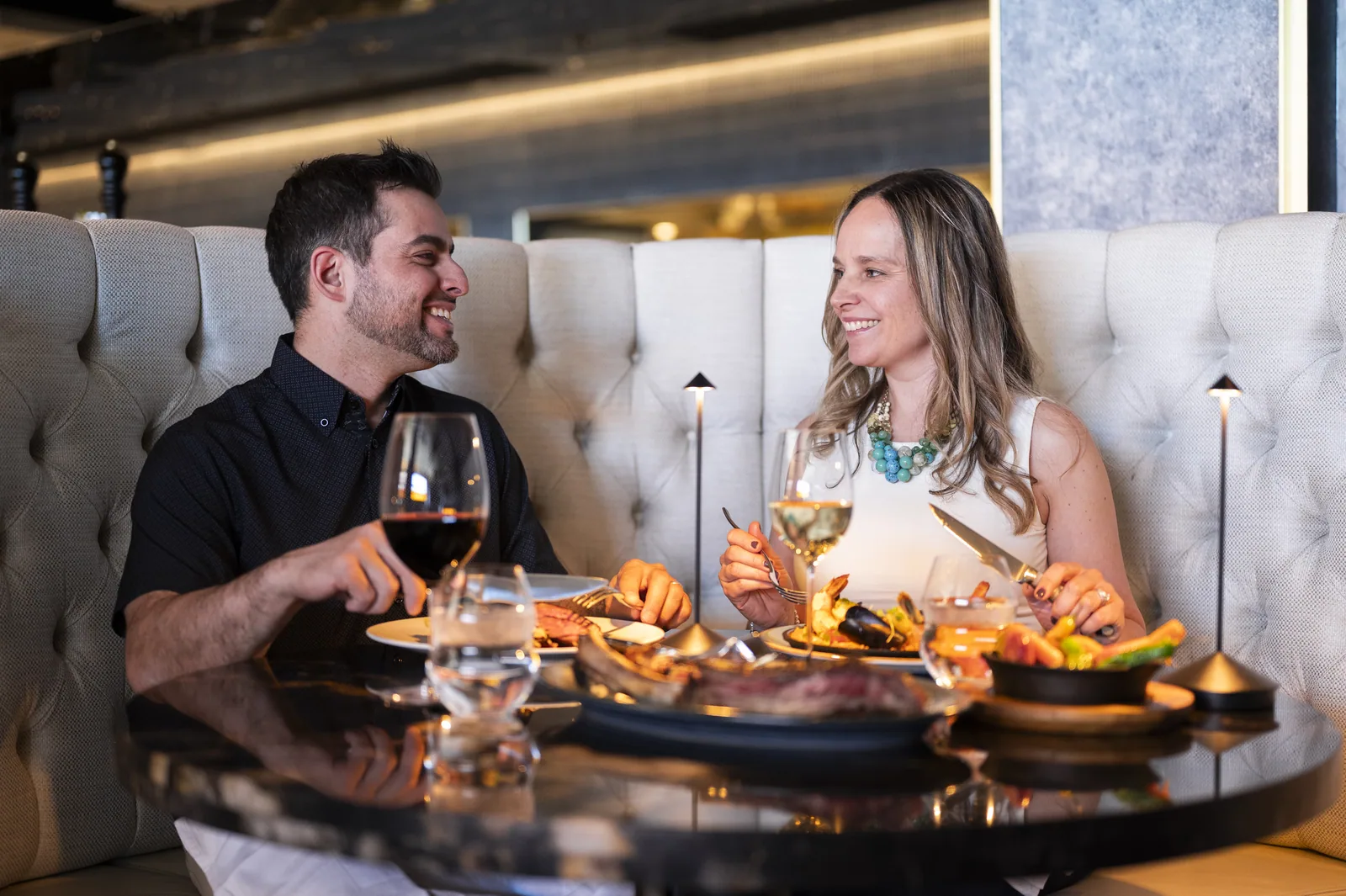 Couple smiling at each other while dining at a fine restaurant at Casino Rama Resort