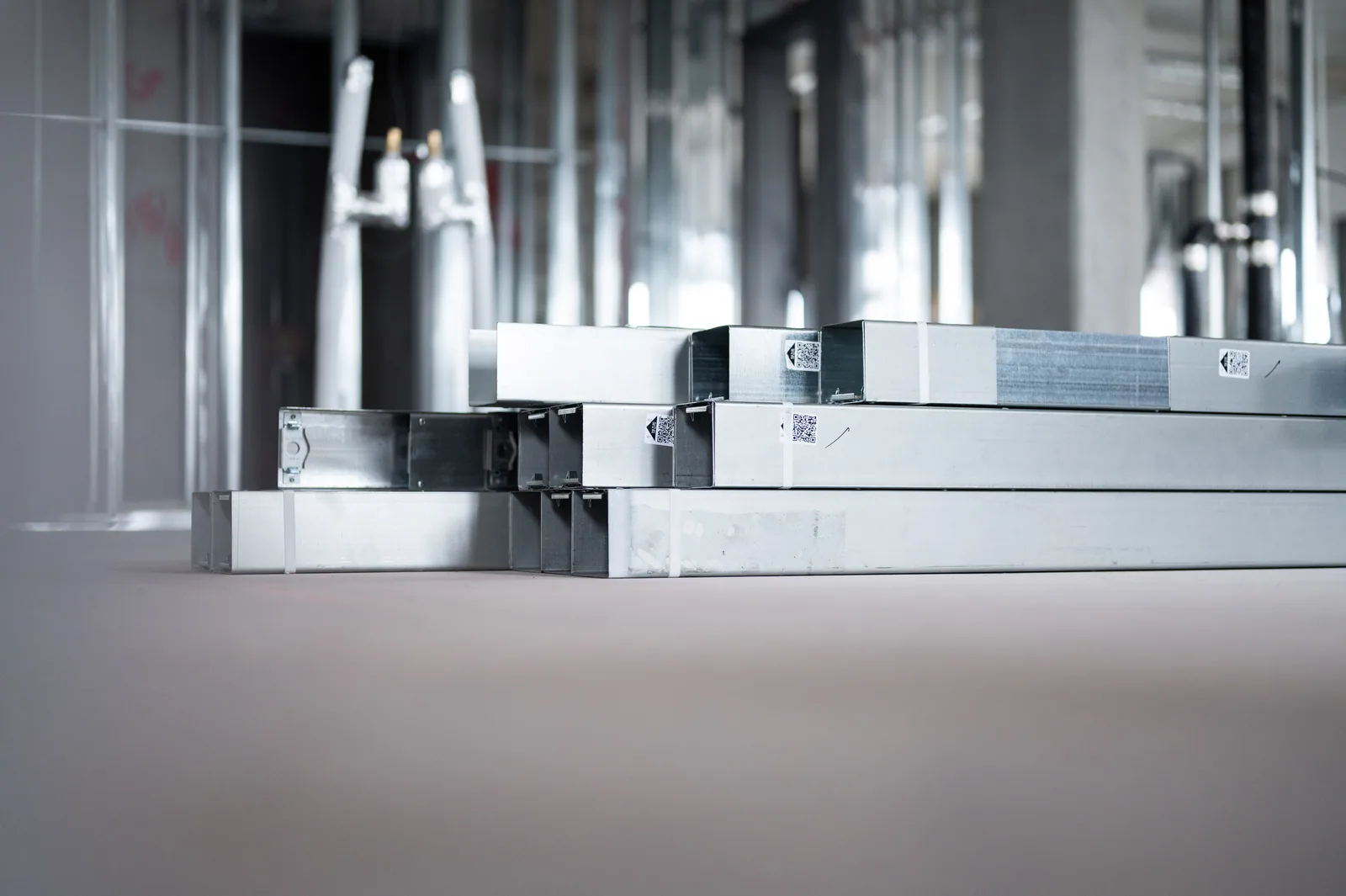Stacks of metal construction materials in an unfinished corporate building interior
